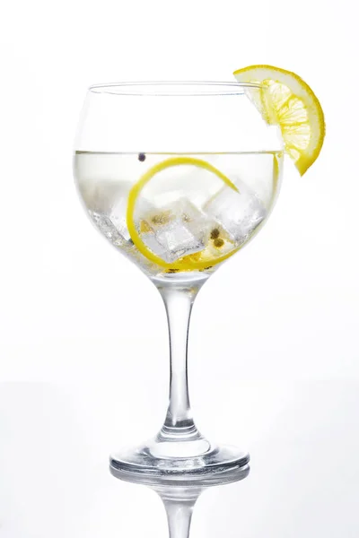 Vaso de gin tonic con limón sobre fondo blanco — Foto de Stock
