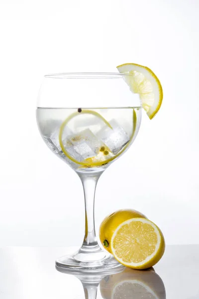 Glass of gin tonic with lemon on white background — Stock Photo, Image