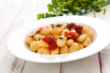Gnocchi Beyaz ahşap masa üzerinde domates soslu