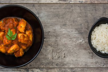 Ahşap masa üzerinde bir kapta tavuk tikka masala