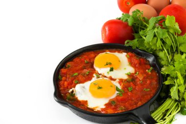 Meksika Kahvaltı: Huevos rancheros demir tavada beyaz arka plan üzerinde izole