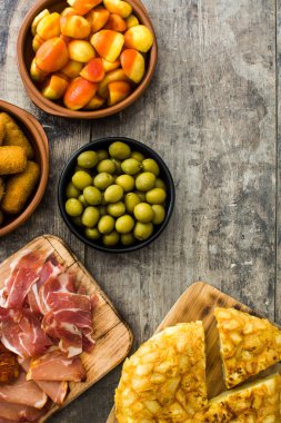 Geleneksel İspanyolca tapas. Ahşap masa üzerinde kroket, zeytin, omlet, jambon ve patatas bravas