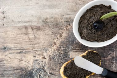 Hamsi, sarımsak ve zeytinyağı ahşap masa üzerinde siyah zeytin tapenade