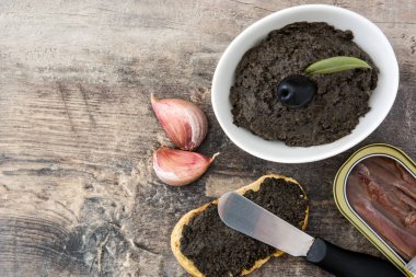 Hamsi, sarımsak ve zeytinyağı ahşap masa üzerinde siyah zeytin tapenade