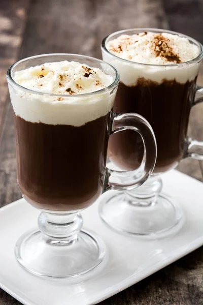 Irish coffee in glass on wooden background