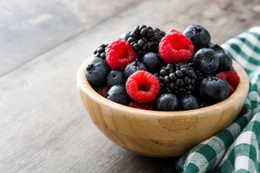 Ahşap masa üzerinde ahşap kase sağlıklı meyveleri