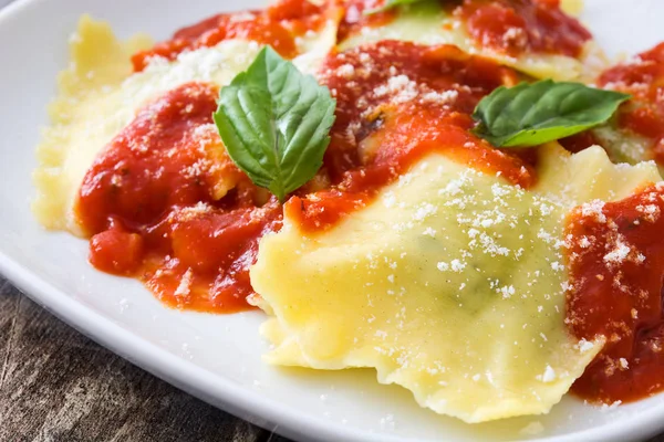 Ravioli con salsa de tomate y albahaca sobre mesa de madera —  Fotos de Stock