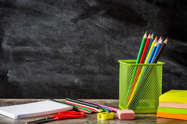 Fournitures scolaires sur table en bois et tableau noir. Retour à l'école. Espace de copie . — Photo