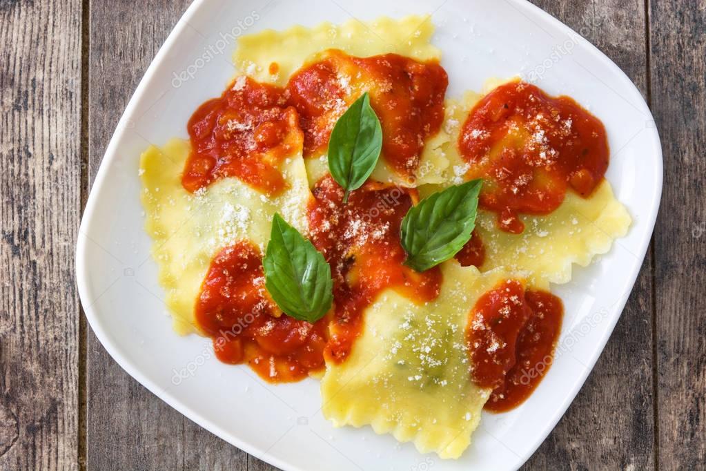 Ravioli with tomato sauce and basil on wooden table