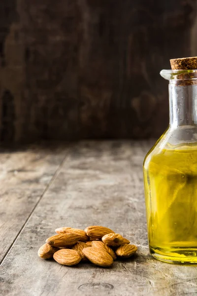 Мигдальна олія в пляшці на дерев'яному столі — стокове фото