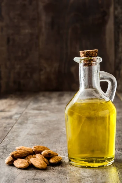 Aceite de almendras en botella sobre mesa de madera — Foto de Stock