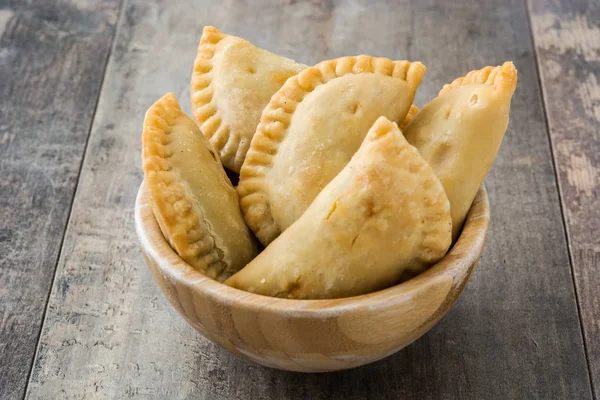 Typical Spanish empanadas in bowl on wooden table — Stock Photo, Image