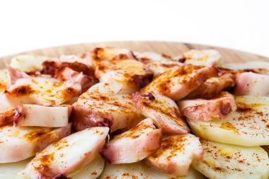Pulpo a la gallega. Beyaz arka plan üzerinde izole Galiçyaca ahtapot. Tipik İspanyol yemeği