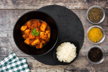 Tavuk tikka masala basmati pirinç ahşap masa üzerinde siyah kase
