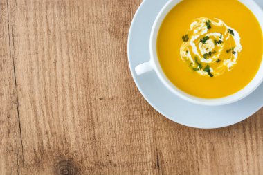 ahşap masa üzerinde beyaz kase kabak çorbası