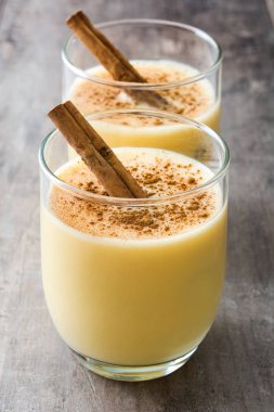 Tarçın ahşap masa üzerinde ev yapımı yumurta likörü. Tipik Noel tatlısı.