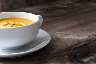 ahşap masa üzerinde beyaz kase kabak çorbası