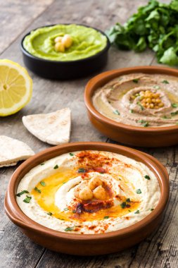 Farklı humus kase. Nohut Humus, avokado humus ve mercimek humus ahşap tablo