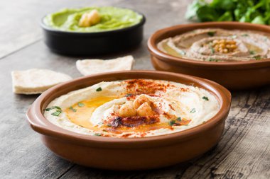 Farklı humus kase. Nohut Humus, avokado humus ve mercimek humus ahşap tablo