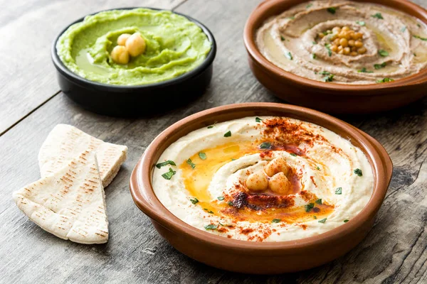 Farklı humus kase. Nohut Humus, avokado humus ve mercimek humus ahşap tablo