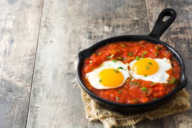 Meksika Kahvaltı: Huevos rancheros demir tavada ahşap tablo