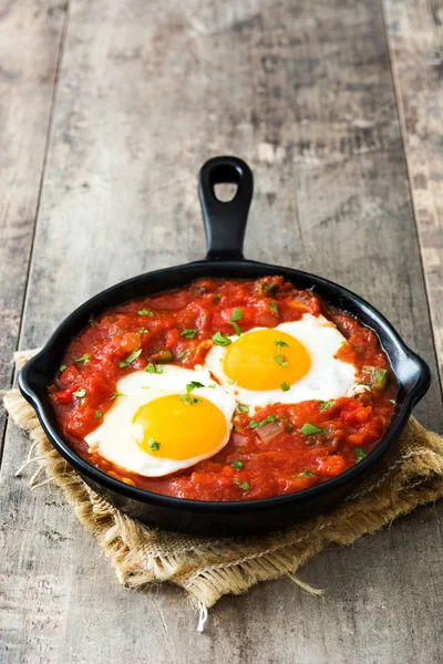 Desayuno mexicano: Huevos rancheros en sartén de hierro sobre mesa de madera —  Fotos de Stock