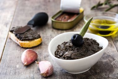 Hamsi, sarımsak ve zeytinyağı ahşap masa üzerinde siyah zeytin tapenade