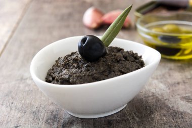 Hamsi, sarımsak ve zeytinyağı ahşap masa üzerinde siyah zeytin tapenade