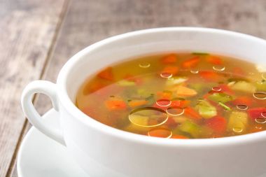 Ahşap masa üzerinde kase sebze çorbası