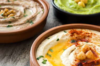 Farklı humus kase. Nohut Humus, avokado humus ve mercimek humus ahşap tablo