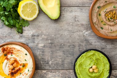 Farklı humus kase. Nohut Humus, avokado humus ve mercimek humus ahşap tablo
