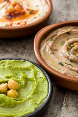 Farklı humus kase. Nohut Humus, avokado humus ve mercimek humus ahşap tablo