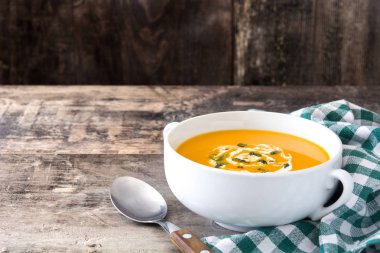 ahşap masa üzerinde beyaz kase kabak çorbası