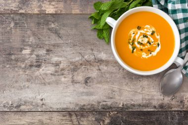 ahşap masa üzerinde beyaz kase kabak çorbası