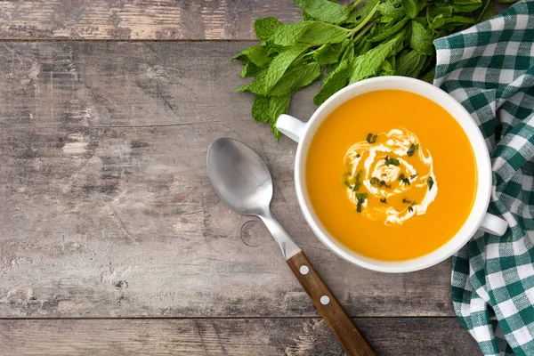 ahşap masa üzerinde beyaz kase kabak çorbası