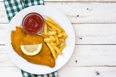 Beyaz ahşap zemin üzerinde patates kızartması ile Wiener schnitzel