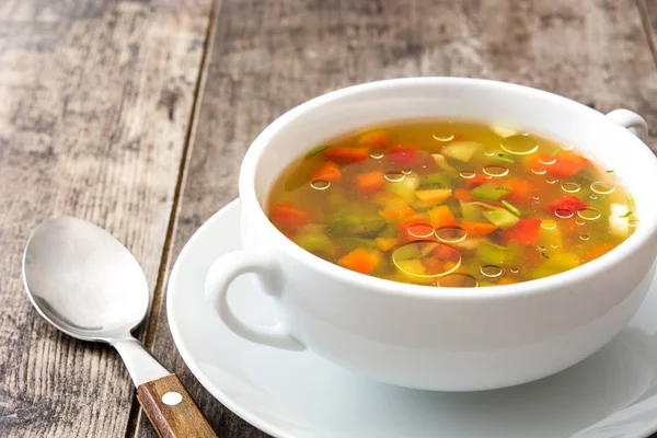 Sopa de legumes na tigela na mesa de madeira — Fotografia de Stock