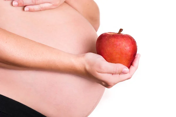 Mulher grávida com uma maçã vermelha isolada no fundo branco — Fotografia de Stock