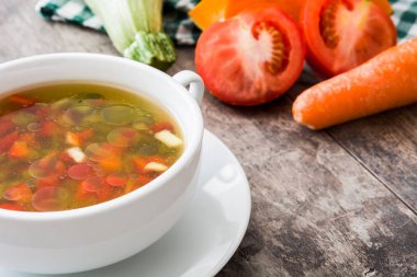 Ahşap masa üzerinde kase sebze çorbası