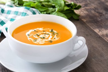 ahşap masa üzerinde beyaz kase kabak çorbası