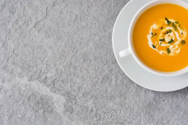 Gri taş üzerinde beyaz kase kabak çorbası