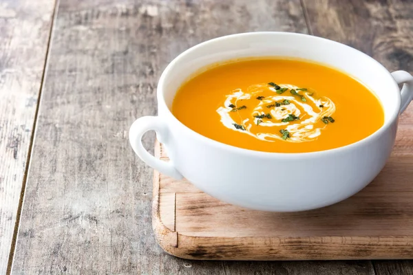 ahşap masa üzerinde beyaz kase kabak çorbası