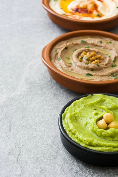 Farklı humus kase. Nohut Humus, avokado humus ve mercimek humus gri taş