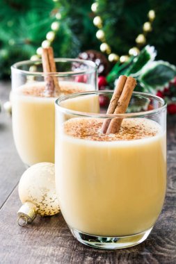 Tarçın ahşap masa üzerinde ev yapımı yumurta likörü. Tipik Noel tatlısı.