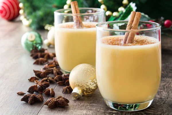 Tarçın ahşap masa üzerinde ev yapımı yumurta likörü. Tipik Noel tatlısı.