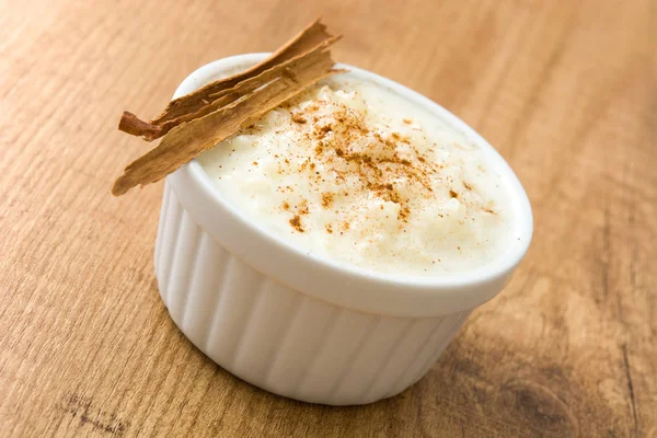 Arroz con leche. Рисовый пудинг с корицей на деревянном фоне — стоковое фото