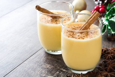 Tarçın ahşap masa üzerinde ev yapımı yumurta likörü. Tipik Noel tatlısı.