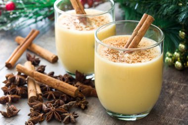 Tarçın ahşap masa üzerinde ev yapımı yumurta likörü. Tipik Noel tatlısı.