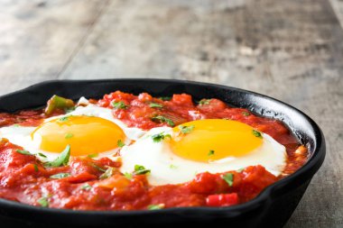Meksika Kahvaltı: Huevos rancheros demir tavada ahşap tablo
