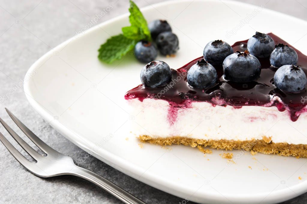 Piece of blueberry cheesecake on gray stone